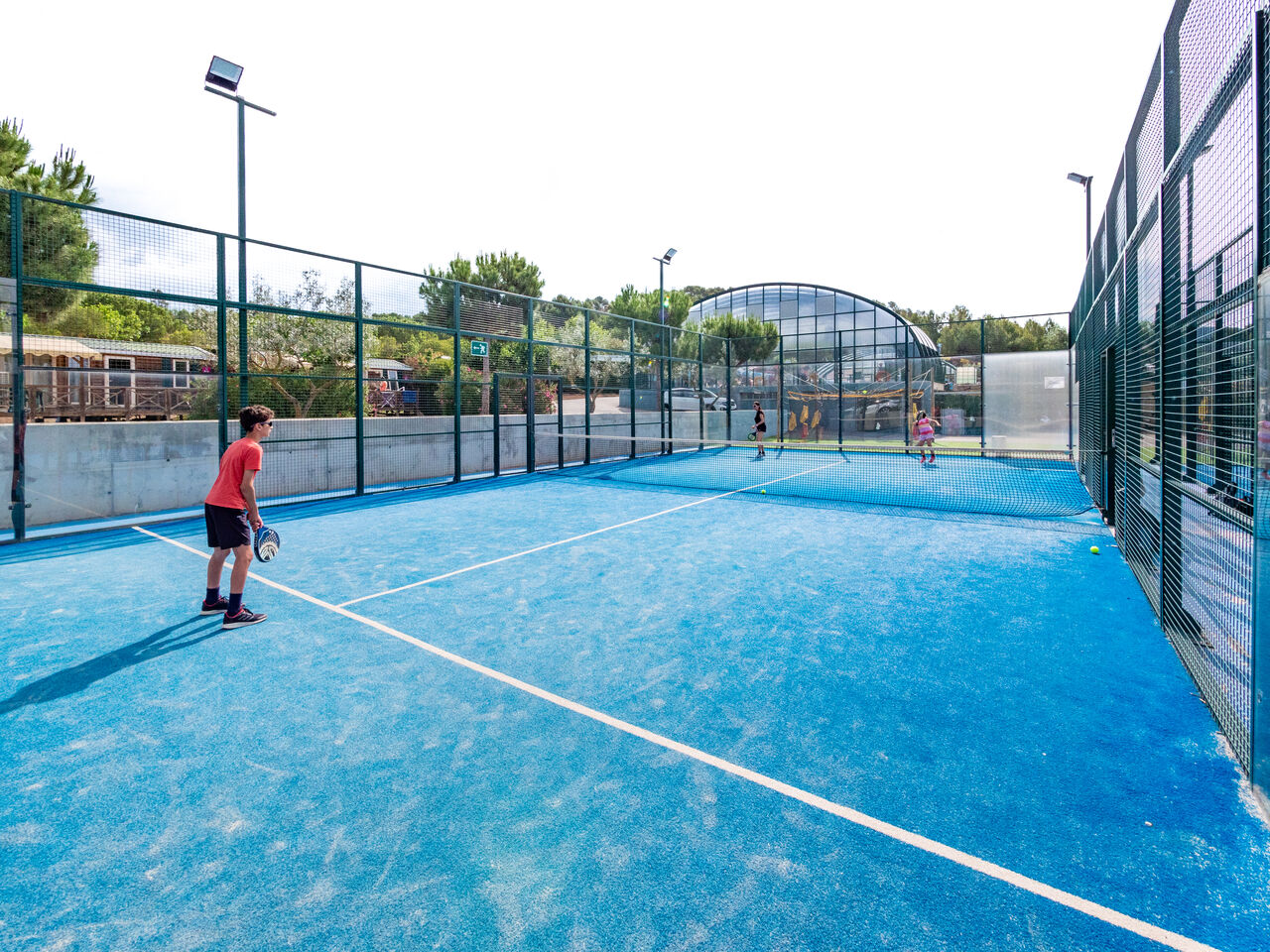 Padel court bleu avec joueurs, activit� sportive au camping CAPFUN Montblanc Park.