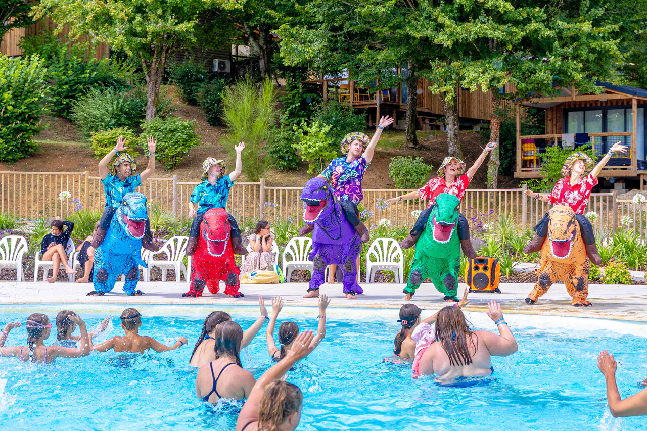 Animateurs en costumes de dinosaures animant la piscine avec enfants au camping CAPFUN Moulinal � BIRON (24).