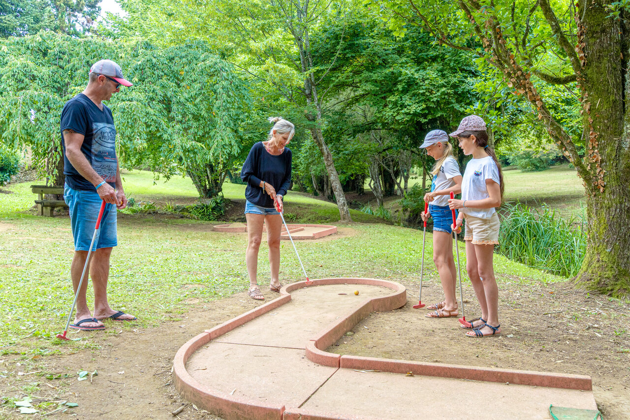 Famille jouant au mini-golf en pleine nature au camping CAPFUN Moulinal � BIRON (24).