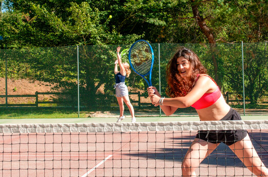 Jeunes femmes jouant au tennis sur le court du camping CAPFUN Moulinal � BIRON (24).