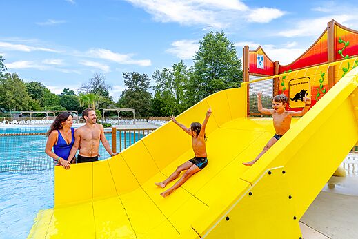 Toboggan aquatique jaune et piscine extérieure au camping CAPFUN Moulinal à BIRON (24).