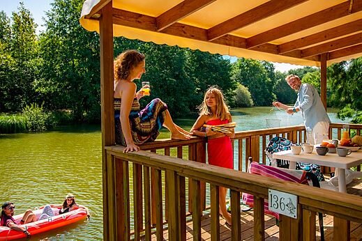 Famille sur terrasse de Mobil-home, lac et activités nautiques CAPFUN Moulinal à BIRON (24).