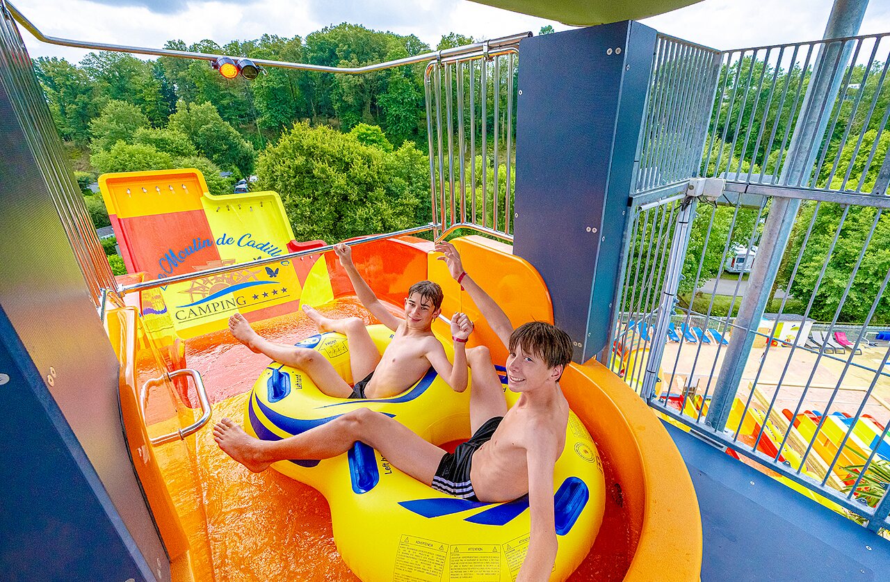 Deux gar�ons sur bou�e dans toboggan aquatique au camping VAGUES OCEANES Moulin de Cadillac � Noyal-Muzillac (56).