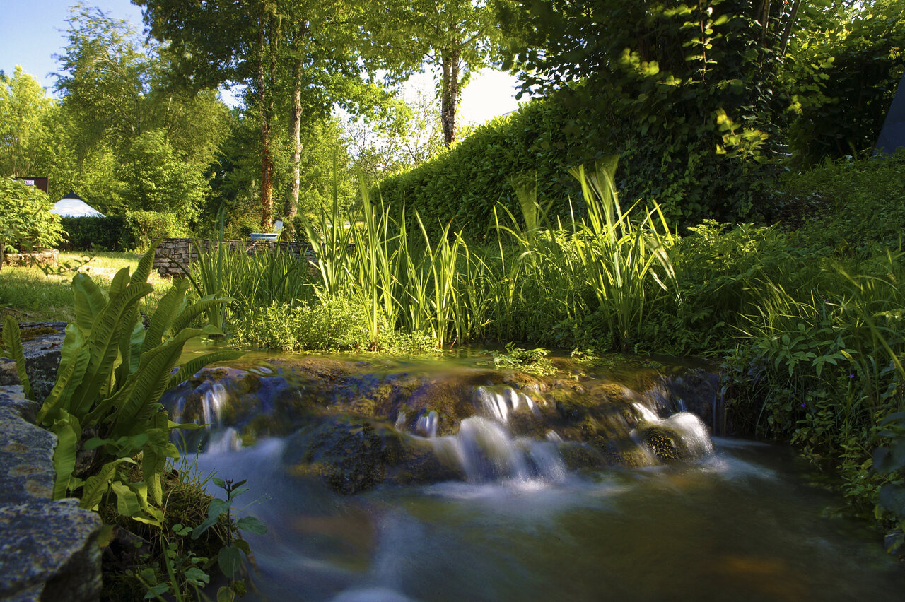 Cascade naturelle et verdure luxuriante au camping CLICOCHIC Moulin du Roch � Saint Andre D'Allas.