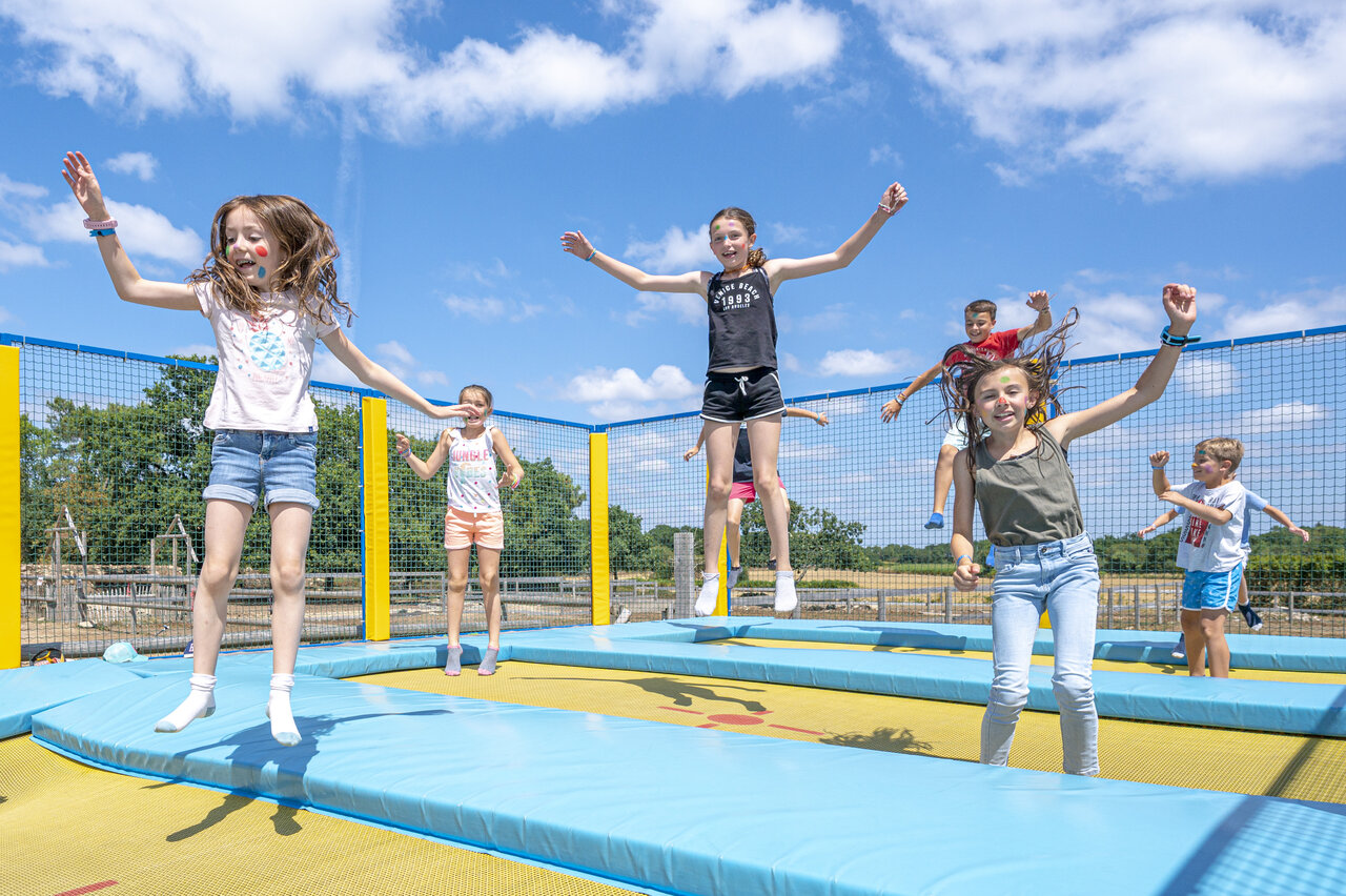 Enfants sautant sur les trampolines g�ants au camping VAGUES OCEANES Moustoir � Carnac (56).