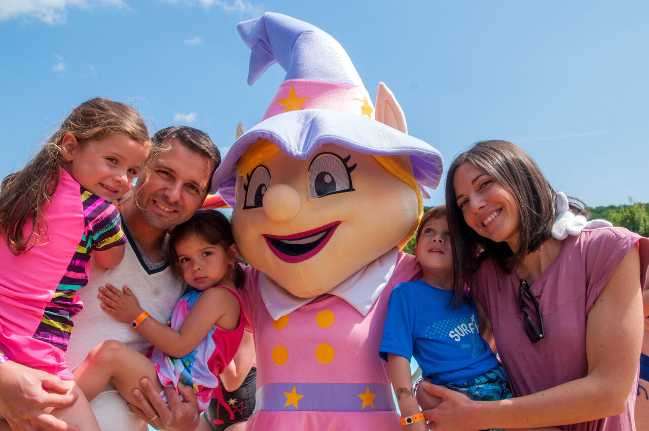 Famille souriante posant avec la mascotte du camping CAPFUN La Nautique � Narbonne (11).