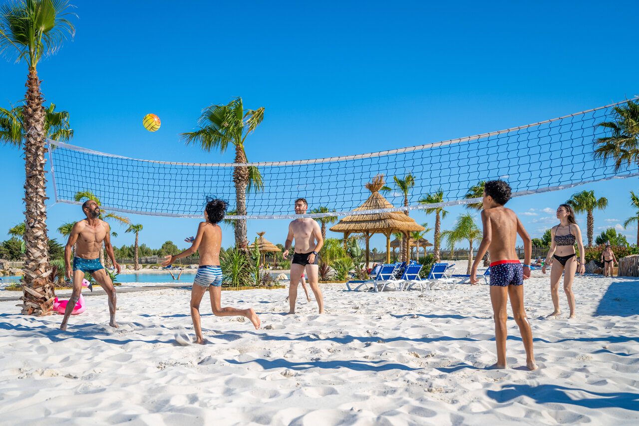 Famille jouant au beach-volley sur la plage de sable fin au camping CAPFUN La Nautique � Narbonne (11).