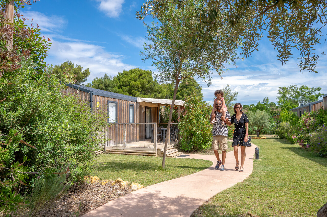 Famille devant Mobil-home moderne et verdoyant au camping CAPFUN La Nautique � Narbonne (11).