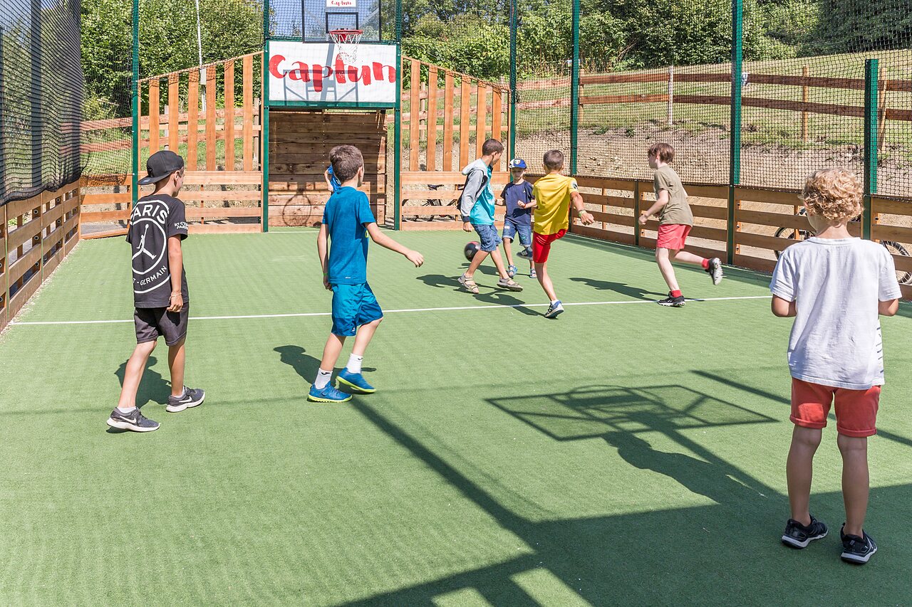 Enfants jouant au football sur terrain multisport Capfun au camping CAPFUN La Nina � Agde (34).