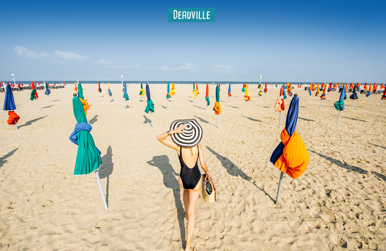 Plage de Deauville avec parasols color�s, lieu � visiter en Normandie.