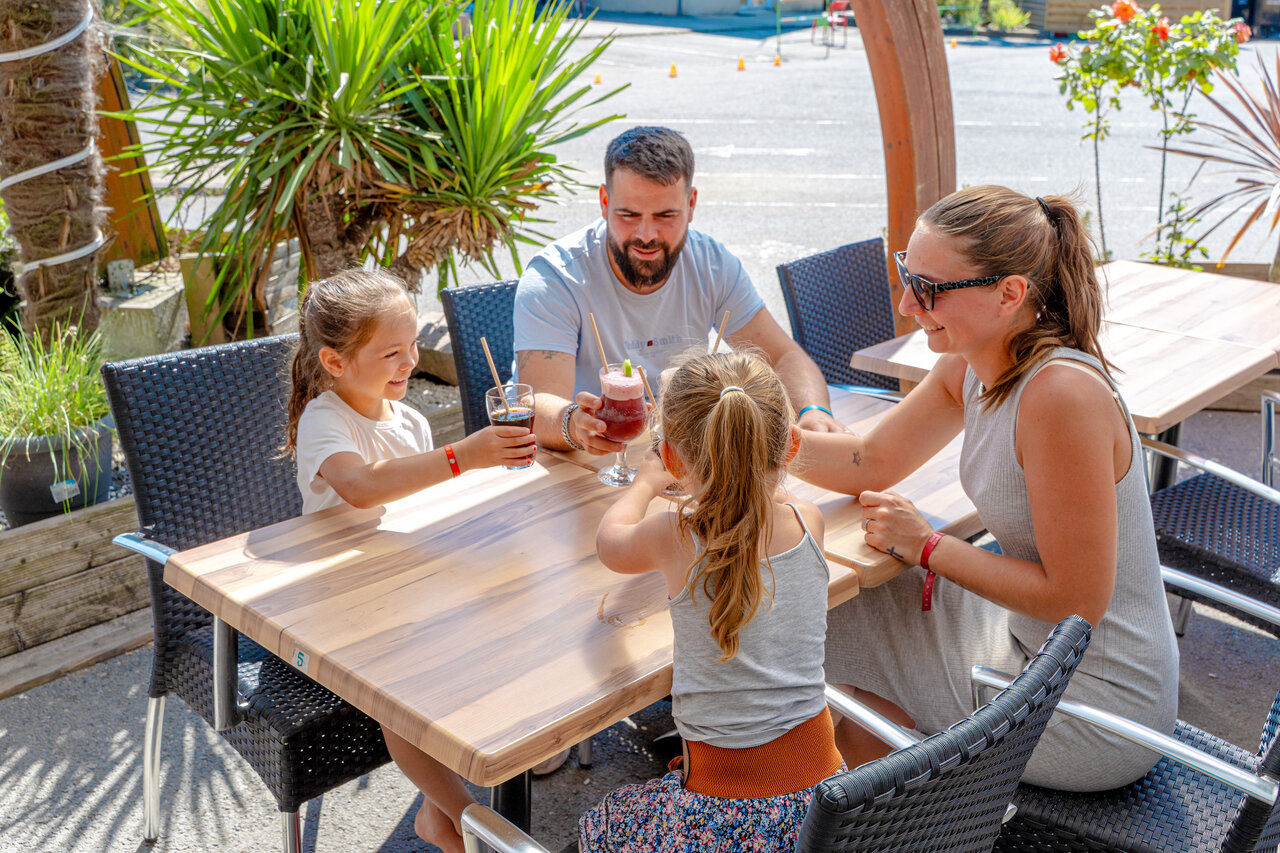 Famille profitant du bar ext�rieur au camping VAGUES OCEANES Odyss�e � Villers sur mer (14).