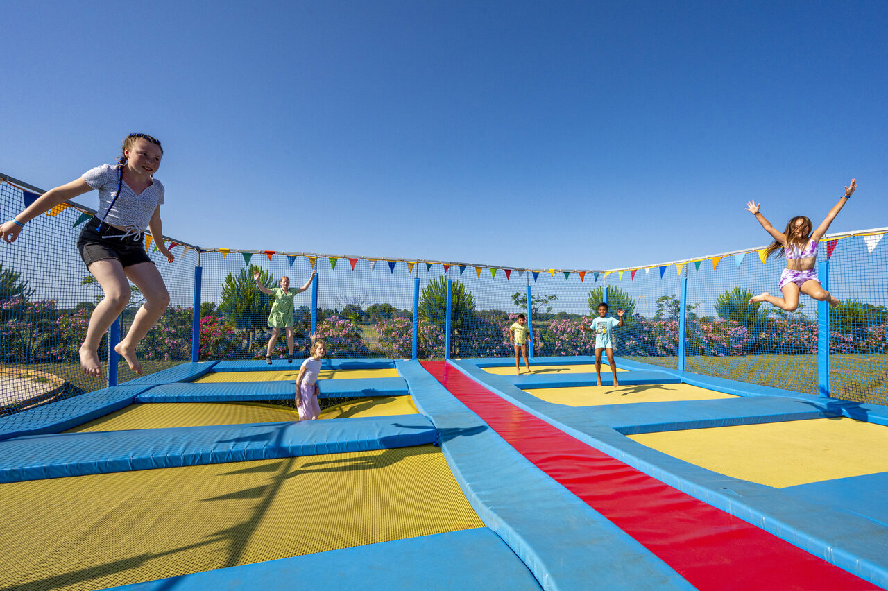Enfants s'amusant sur les trampolines au camping CAPFUN Ondines � Vias Plage (34).