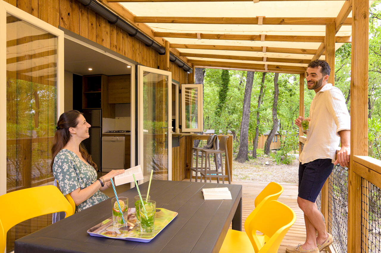 Couple sur terrasse couverte de Mobil-home au camping CLICOCHIC Or�e d'Azur � OPIO (06).