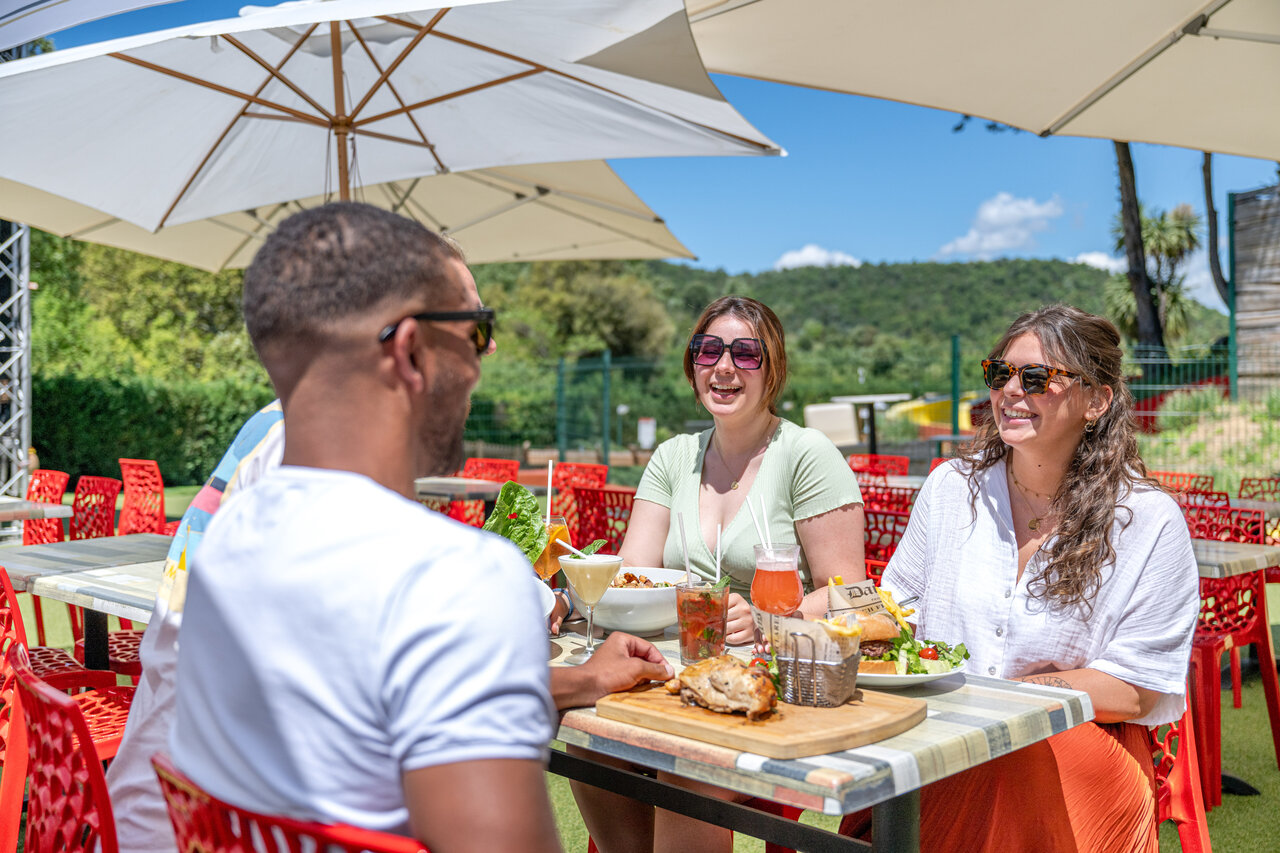 Terrasse de restaurant ext�rieure avec clients d�jeunant au camping CAPFUN Pachacaid � La Mole (83).