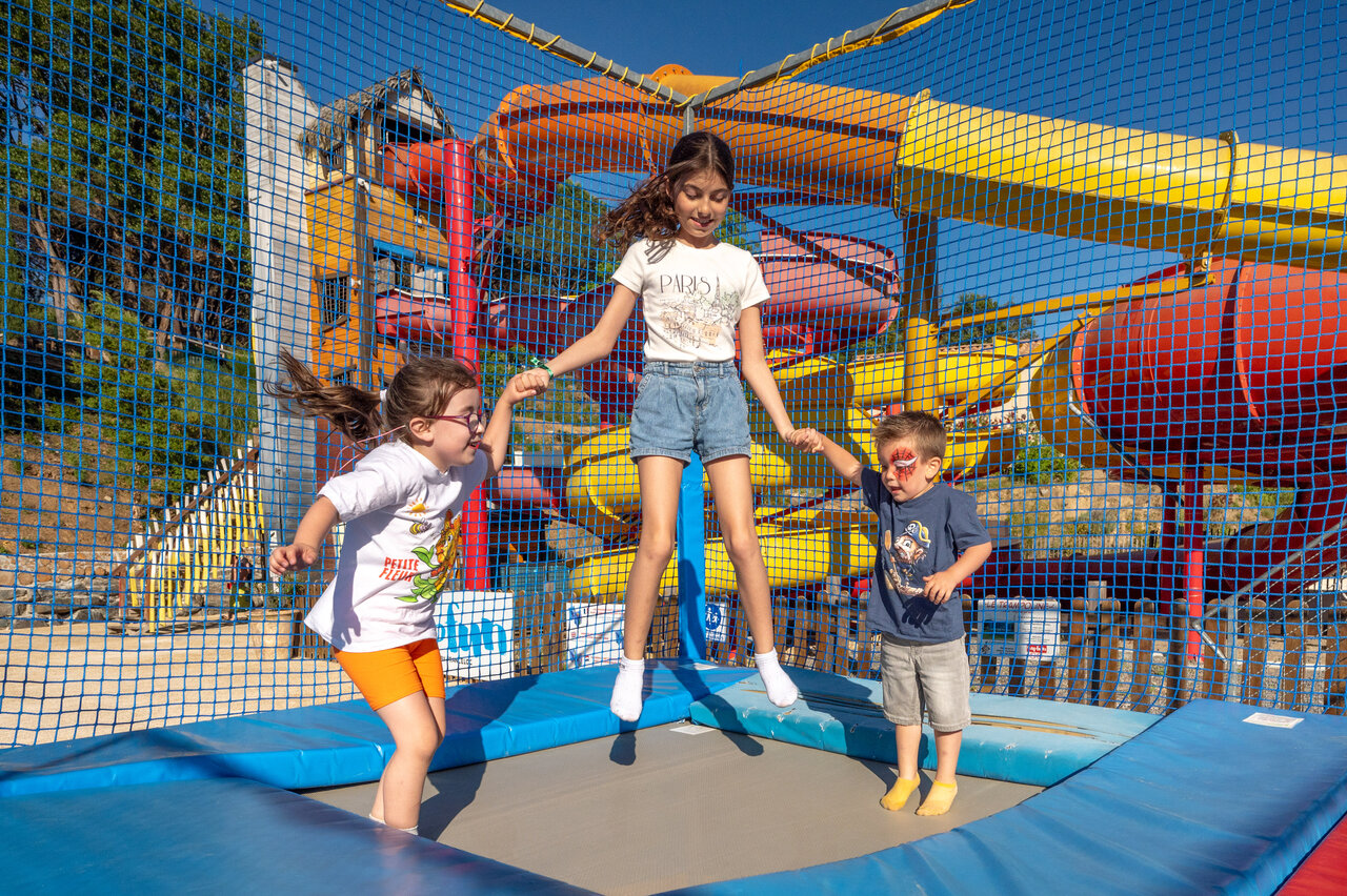 Enfants sautant sur trampoline, toboggans aquatiques color�s au camping CAPFUN Pachacaid � La Mole (83).