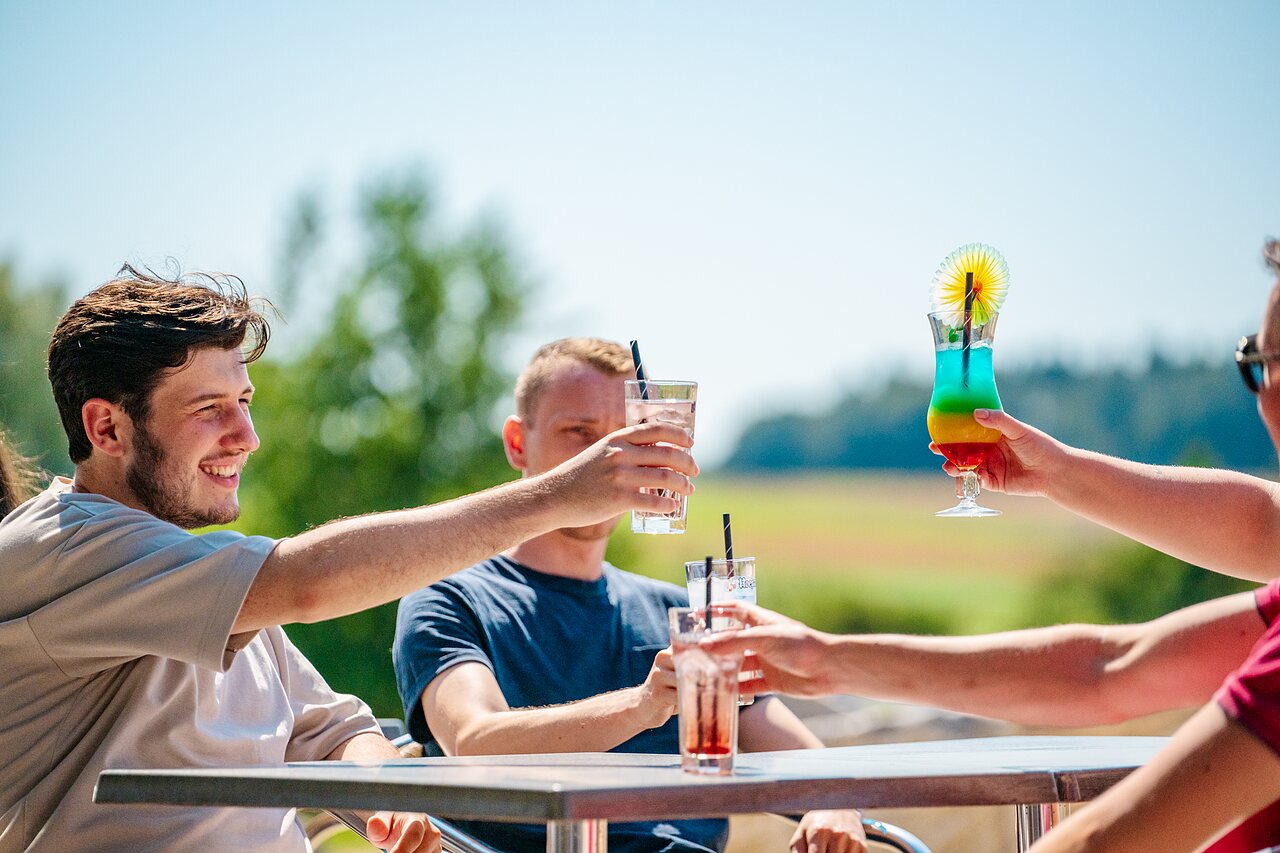 Amis trinquant avec cocktails color�s au bar du camping CAPFUN Pachy � FOSSES LA VILLE.