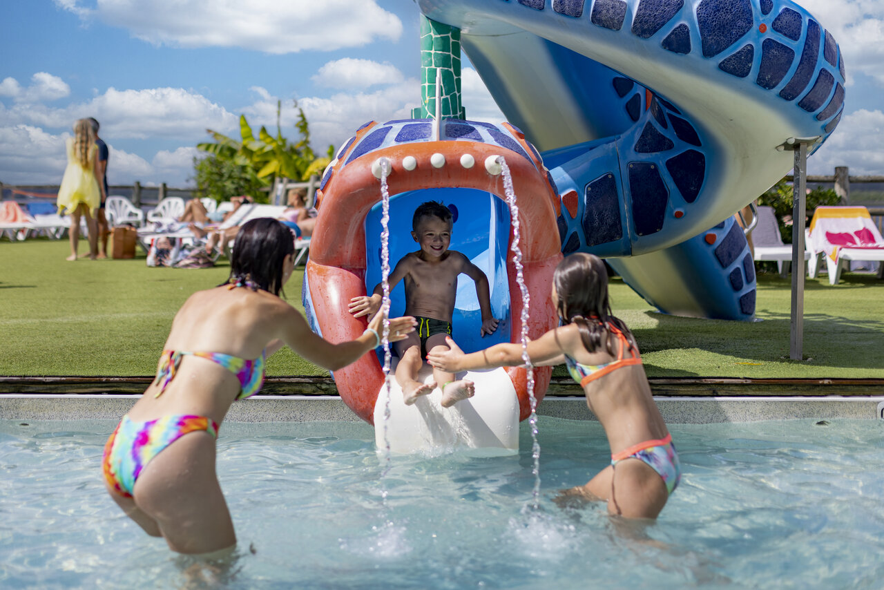 Enfant descendant un toboggan aquatique dans la piscine au camping CAPFUN Paillotte � AZUR (40).