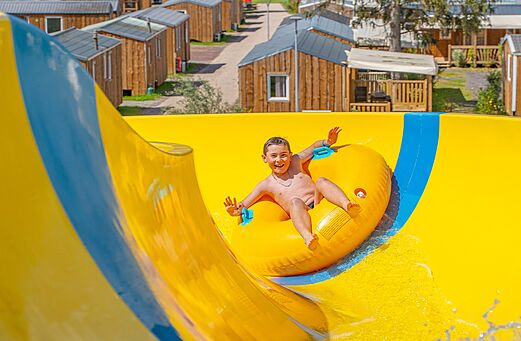 Toboggan aquatique jaune avec enfant au camping CAPFUN Palais de Gaufrette (57).