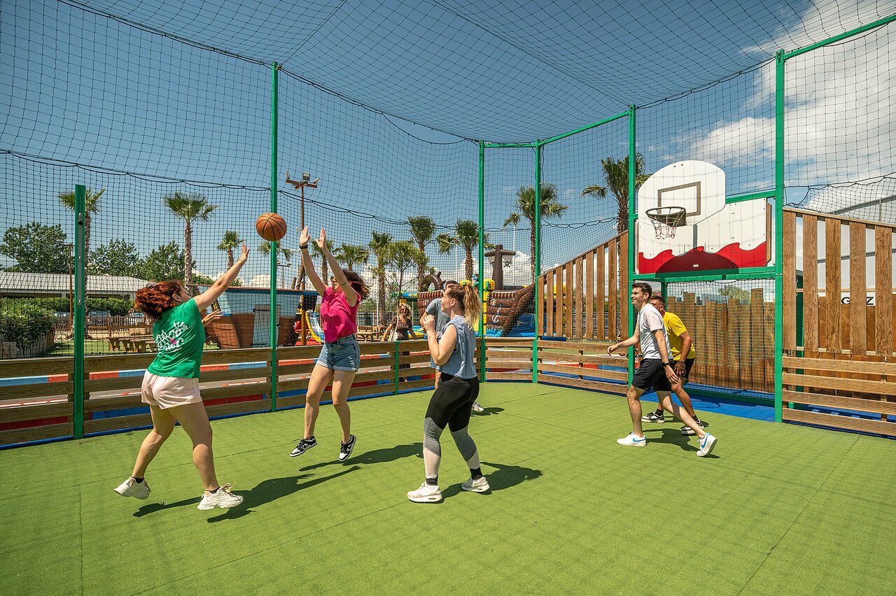 Jeunes jouant au basketball sur terrain multisport cl�tur� au camping CLICOCHIC Palmira Beach � Vendres-Plage (34).