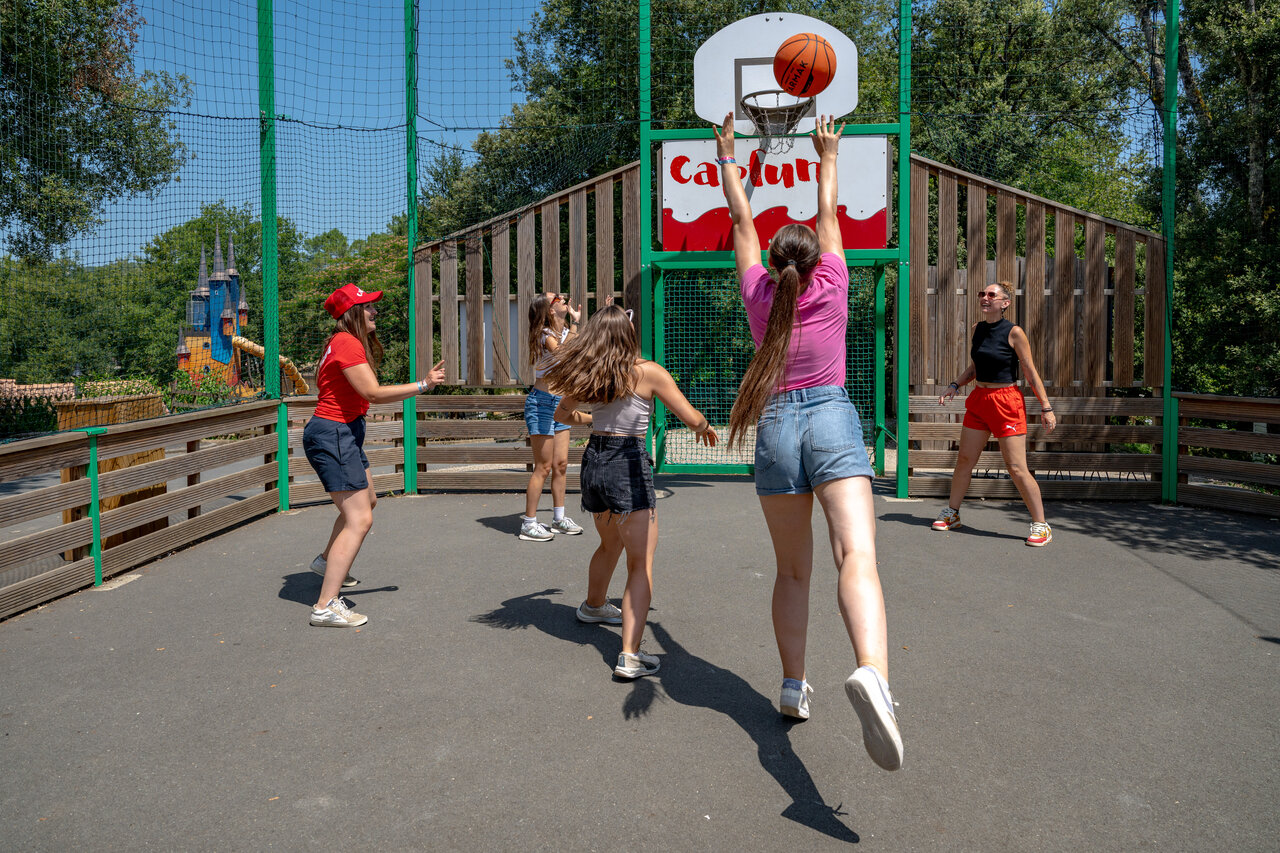 Jeunes jouant au basketball sur terrain multisport au camping CAPFUN Palombi�re � Sarlat.
