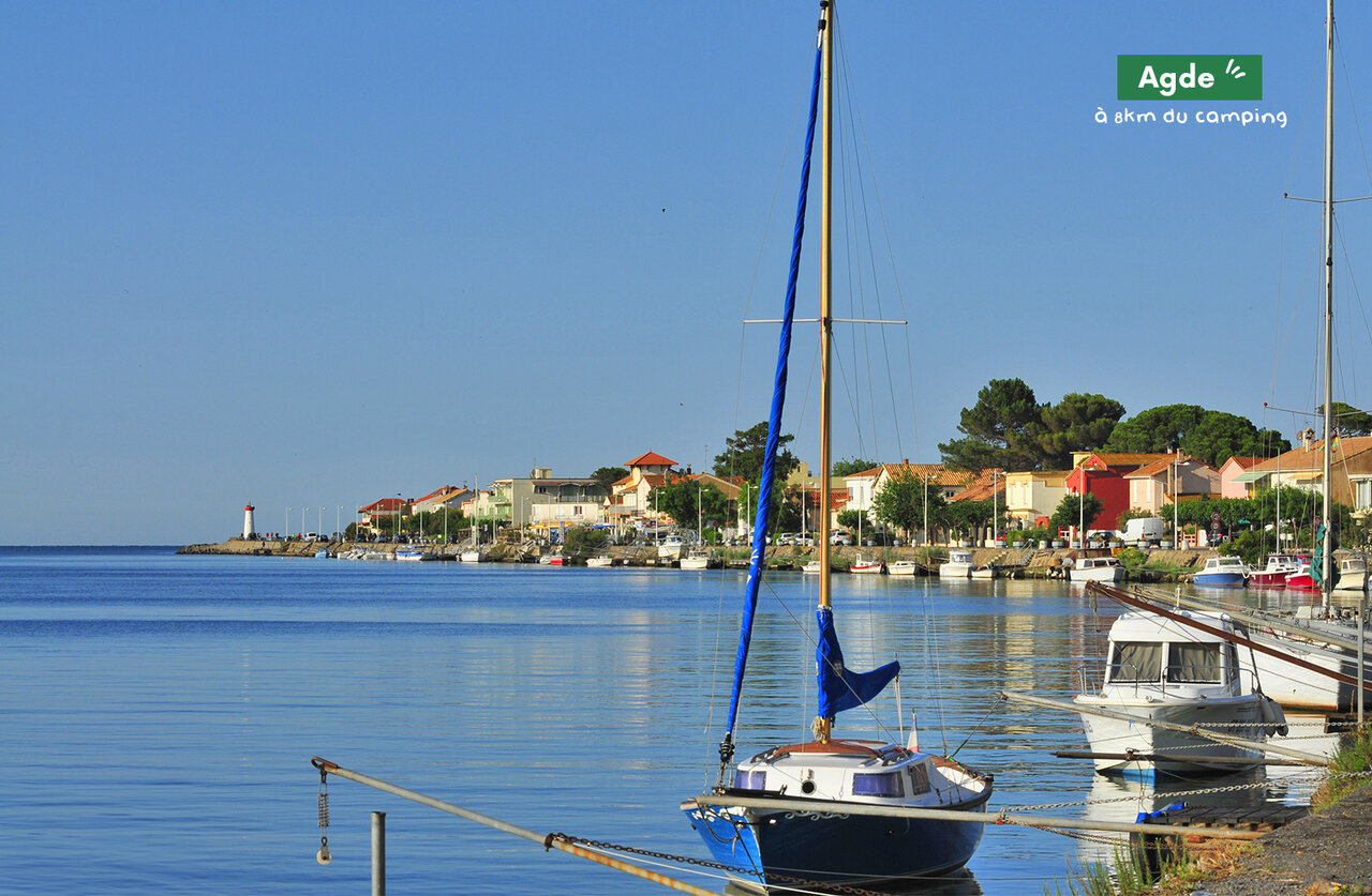 Port d'Agde avec bateaux, maisons color�es et phare, � visiter pr�s du camping.