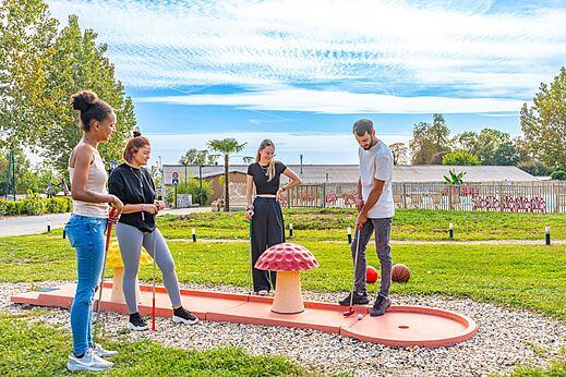 Amis jouant au mini-golf au camping CAPFUN Parc de Paris à Villevaudé (77).