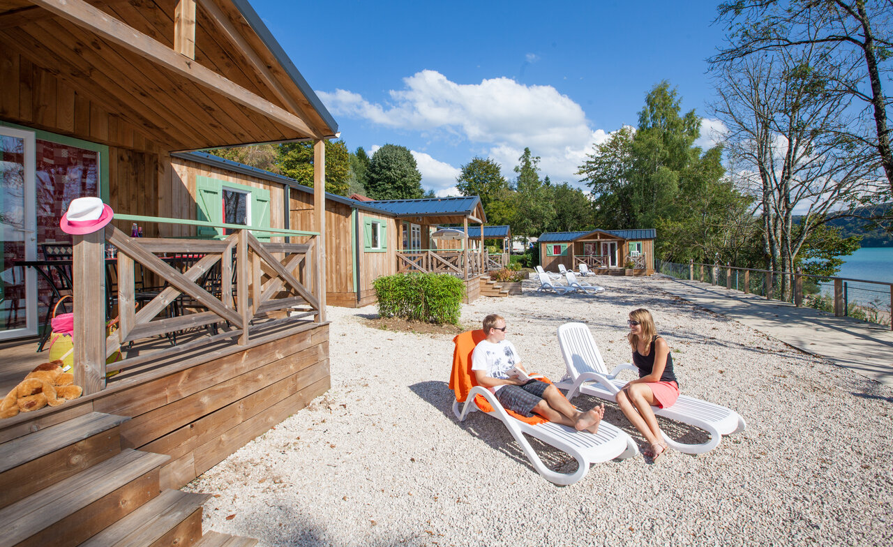 Mobil-homes en bois, couple relaxant, lac au camping CAPFUN Pergola � Marigny (39).