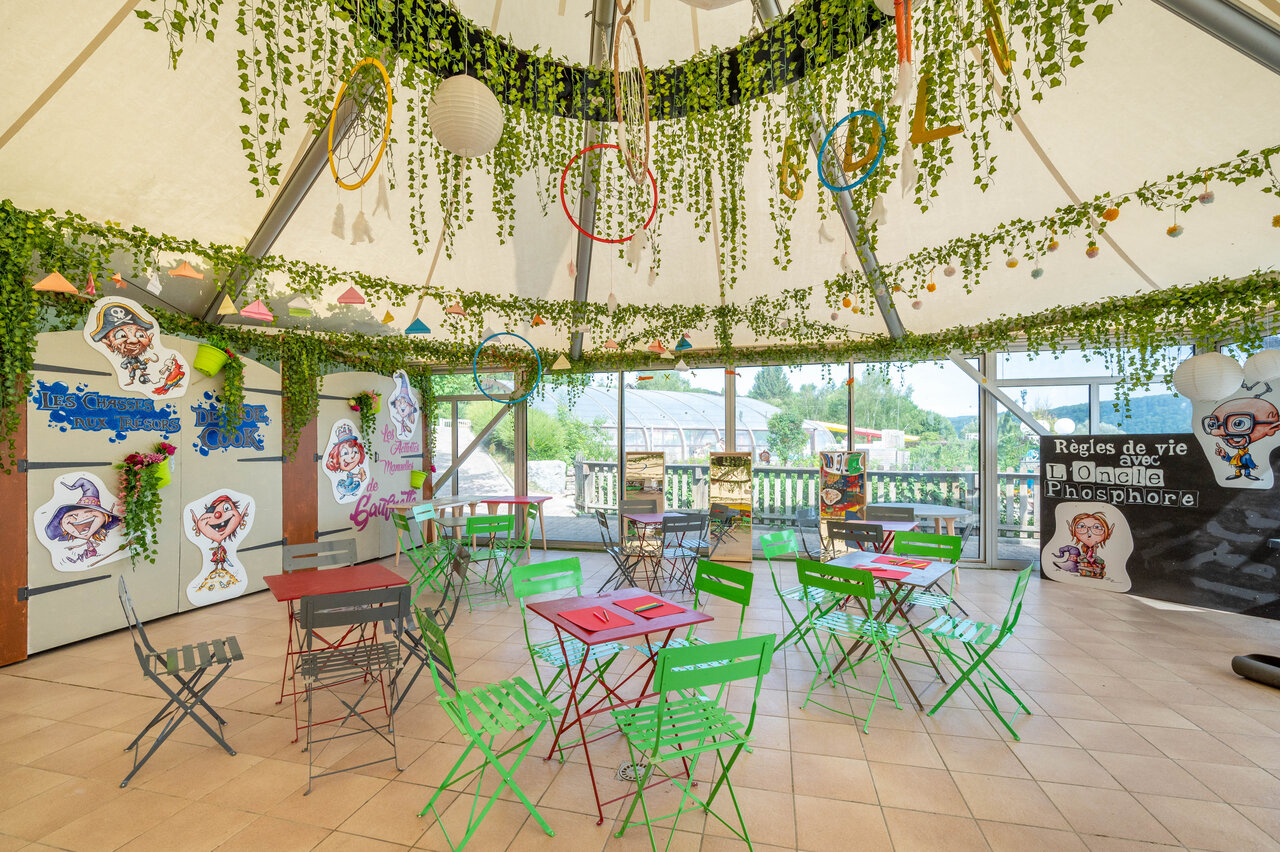 Espace d'animation color� pour enfants avec tables et d�corations au camping CAPFUN Pergola � Marigny (39).