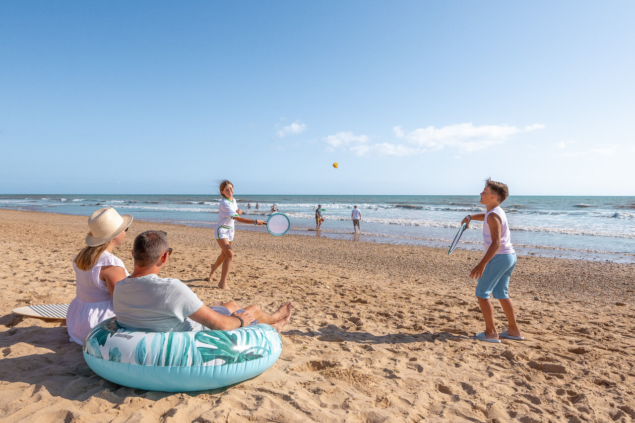 Famille jouant aux raquettes sur la plage au camping CLICOCHIC Petit Bec � St Hilaire de Riez.