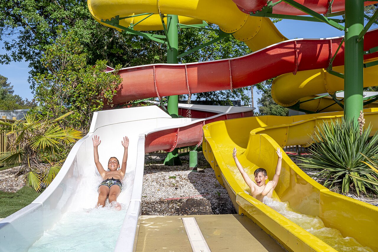 Toboggans aquatiques color�s avec enfants joyeux au camping CAPFUN Pin�da � CAZAUX (33).
