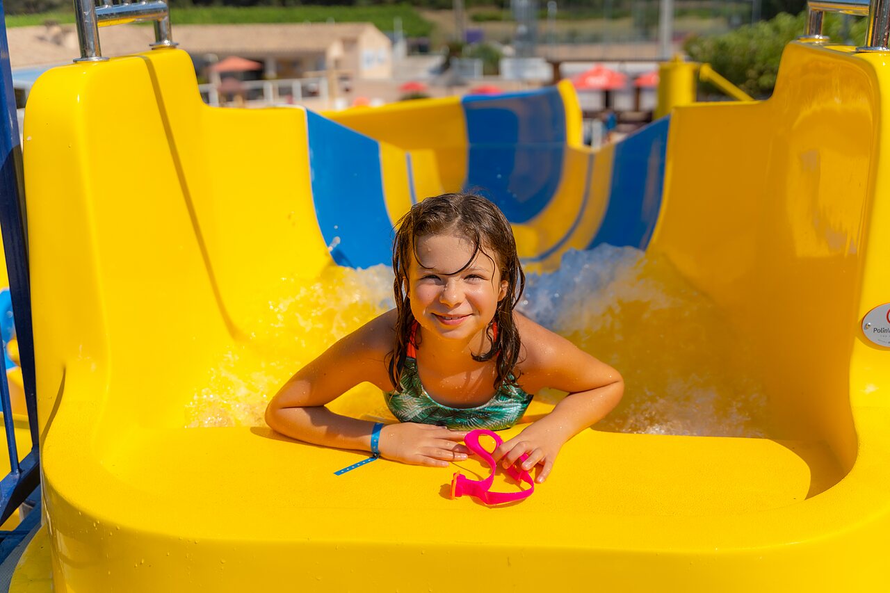 Fille souriante sur toboggan aquatique au camping CAPFUN La Pin�de de Grimaud (83).