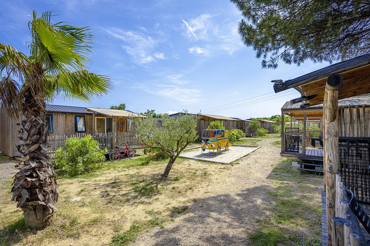 Mobil-homes en bois et aire de jeux au camping CAPFUN La Pin�de de Grimaud.