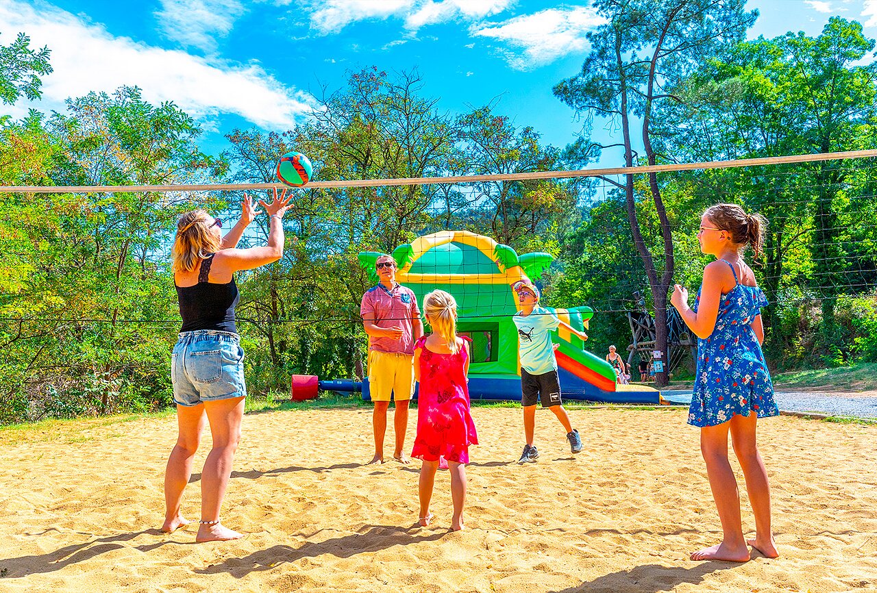 Famille jouant au beach-volley, jeux gonflables au camping CAPFUN Plantas (07).