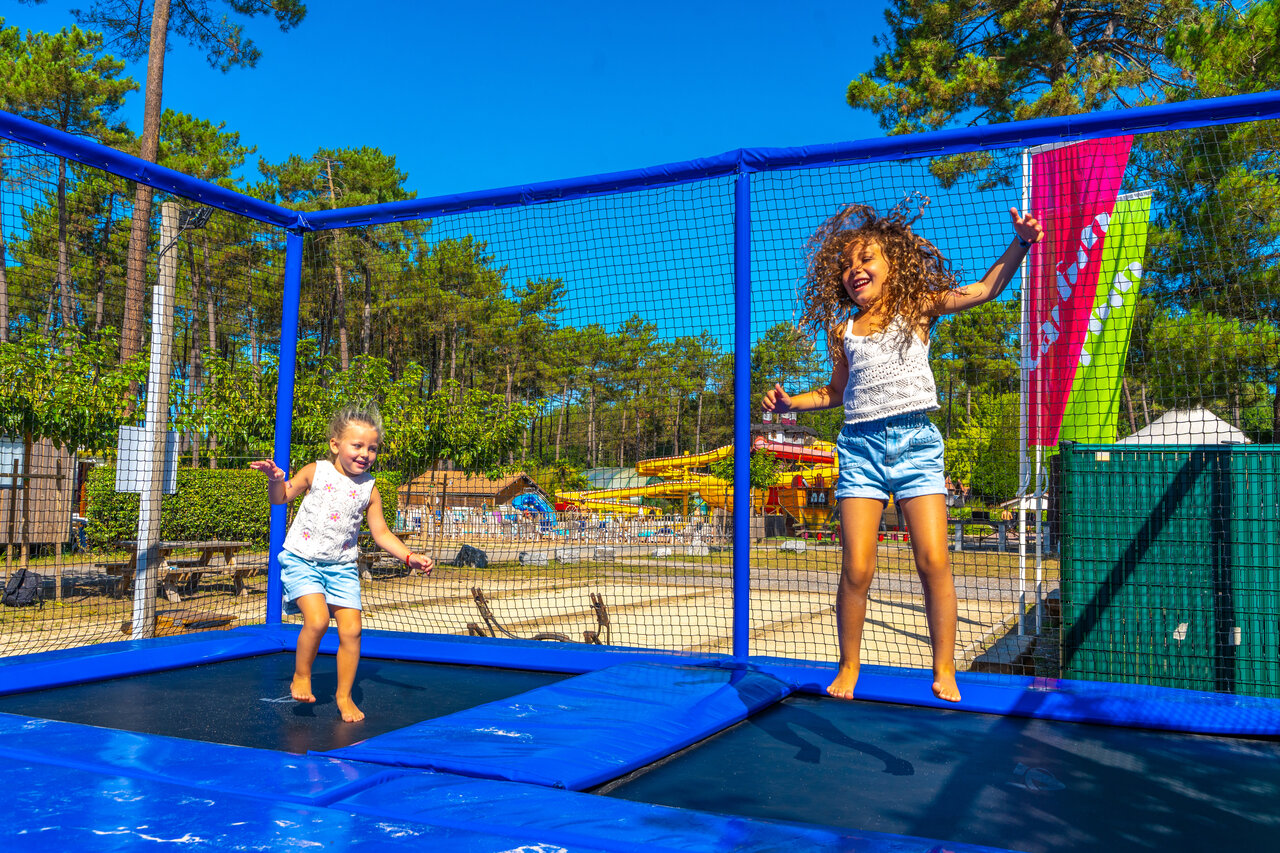 Deux enfants joyeux sautant sur trampolines au camping CAPFUN Pomme de Pin � Saubion (40).