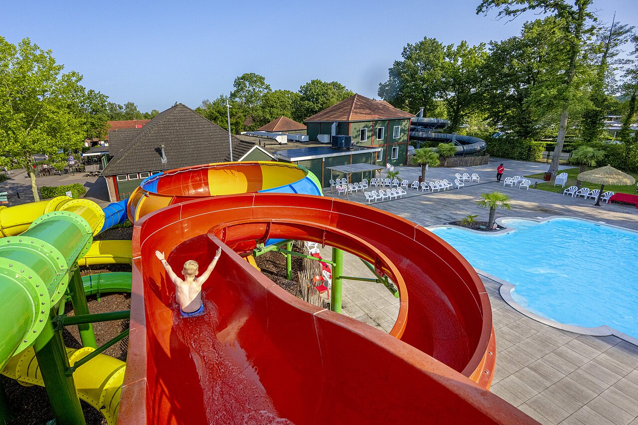 Enfant sur toboggan aquatique g�ant, piscine ext�rieure au camping CAPFUN Ponderosa � Ulicoten.