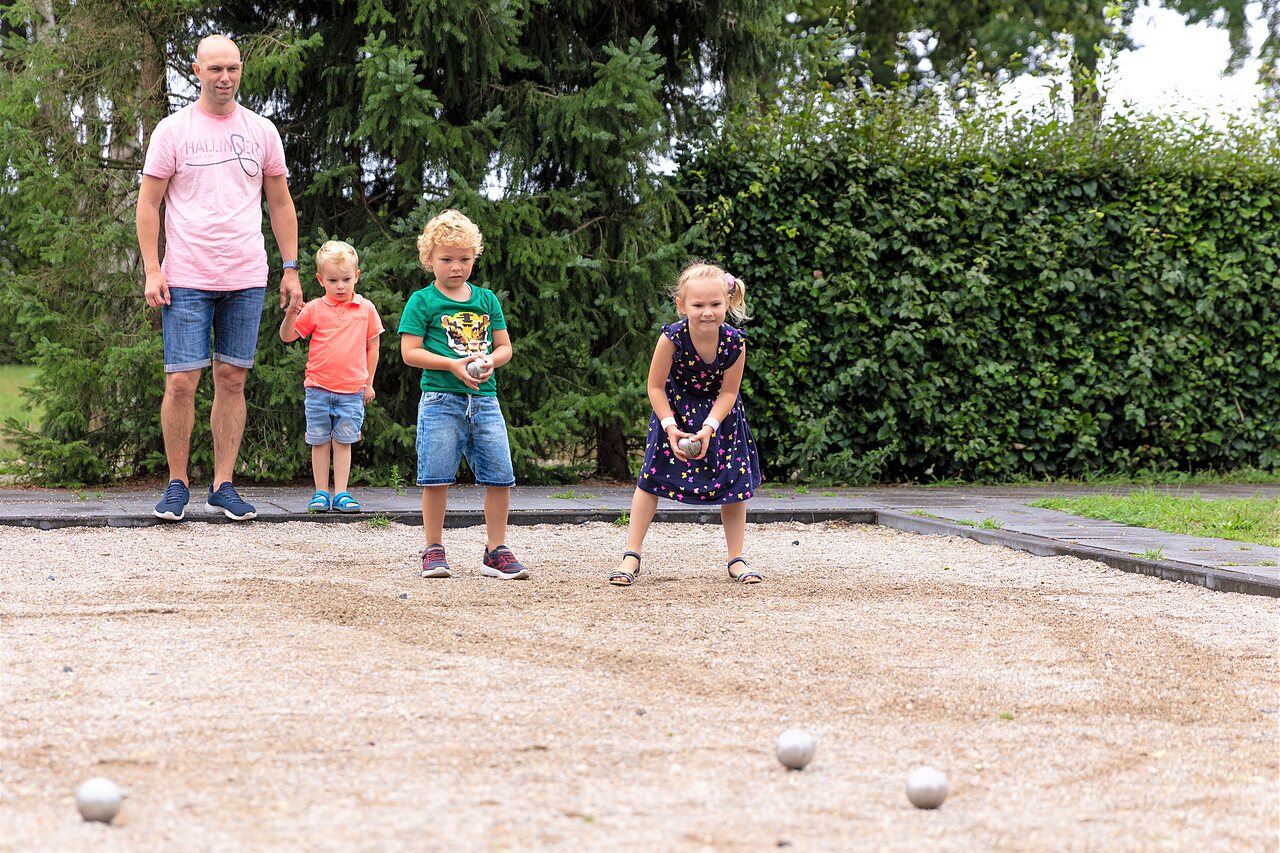 Famille jouant � la p�tanque sur un terrain d�di� au camping CAPFUN Ponderosa � Ulicoten.