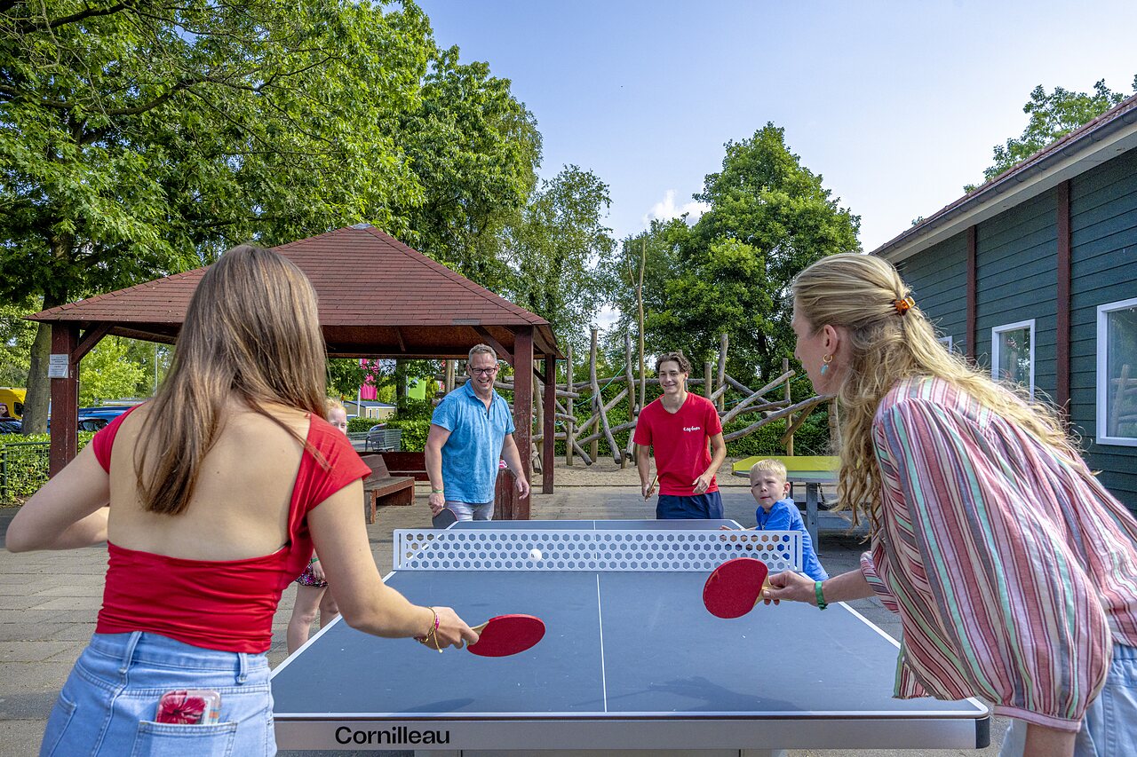 Famille jouant au hockey sur gazon sur un terrain multisport au camping CAPFUN Ponderosa � Ulicoten.