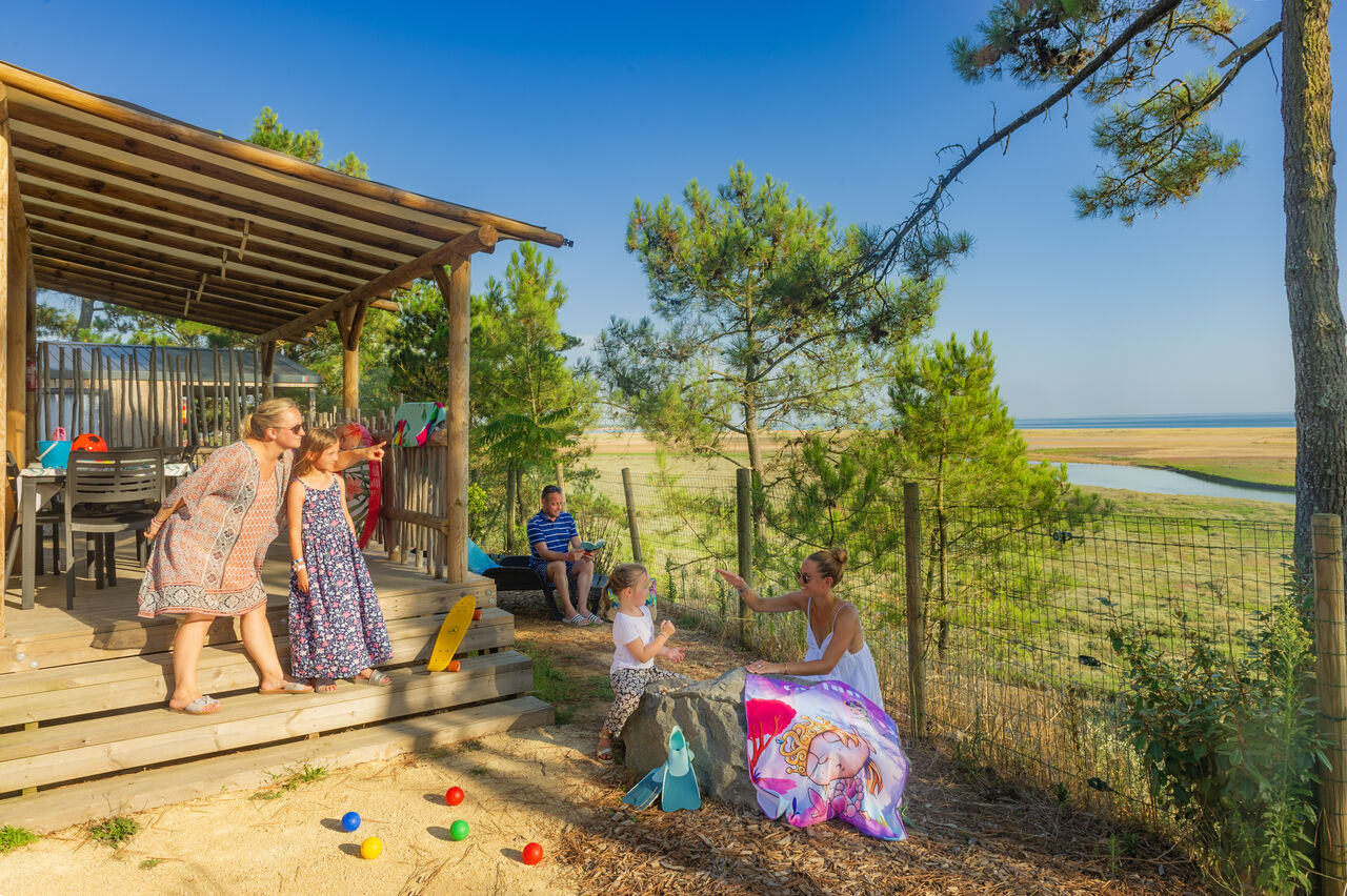 Famille sur terrasse de Mobil-home avec vue mer au camping CAPFUN Prises � La TRANCHE SUR MER (85).