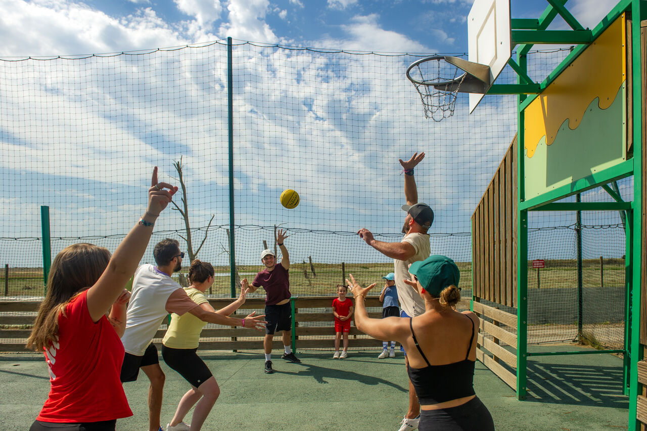 Famille jouant au basketball sur terrain multisport au camping CAPFUN Prises � La TRANCHE SUR MER (85).