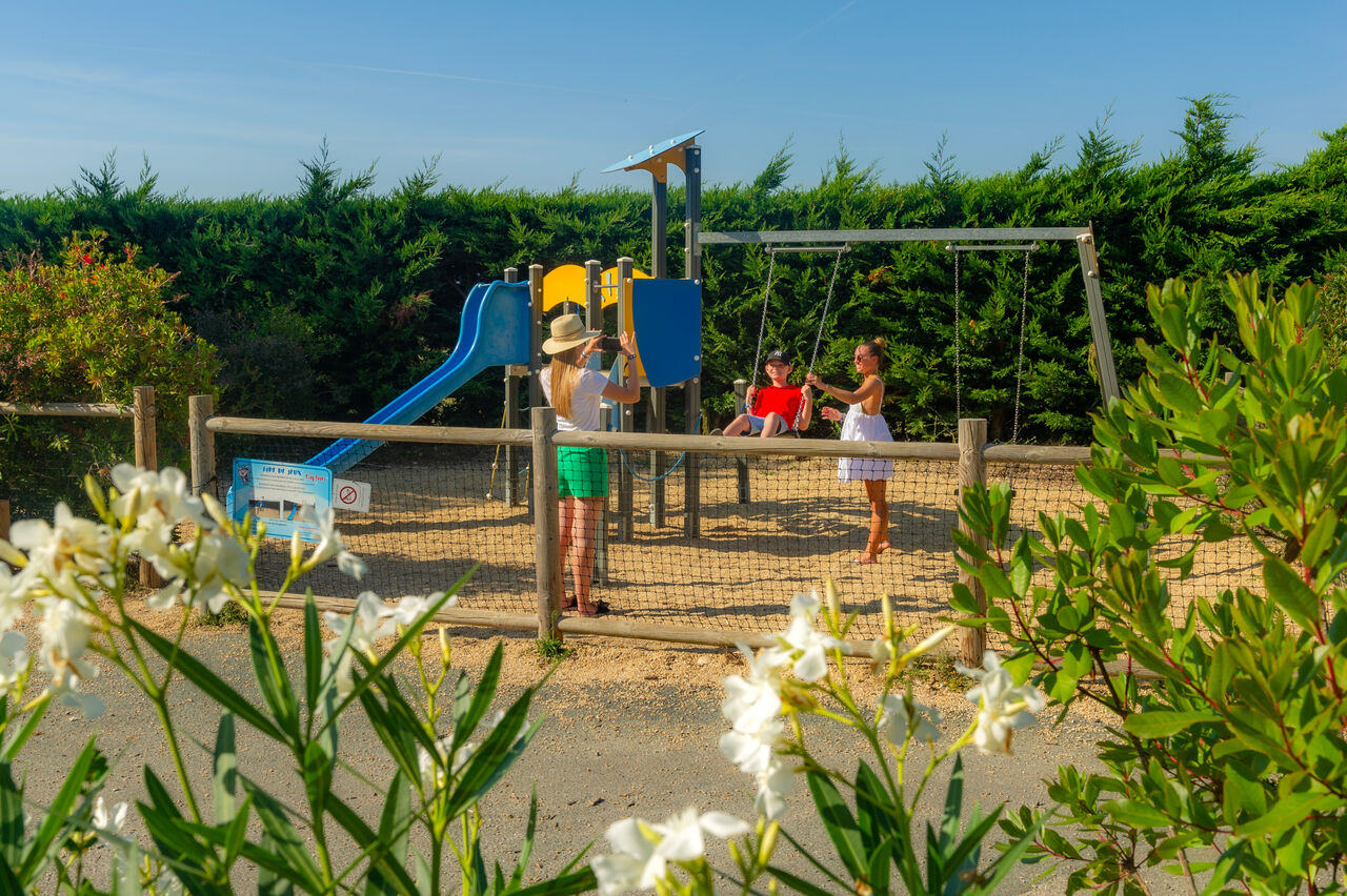 Aire de jeux avec toboggan et balan�oires au camping CAPFUN Prises � La TRANCHE SUR MER (85).