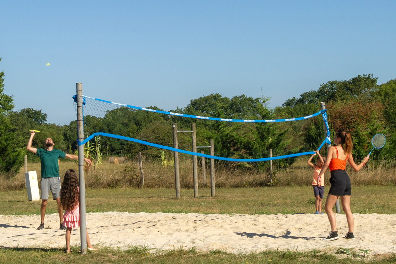Famille joue au badminton sur terrain de sable au CAPFUN Quatre Vents d'Ol�ron.