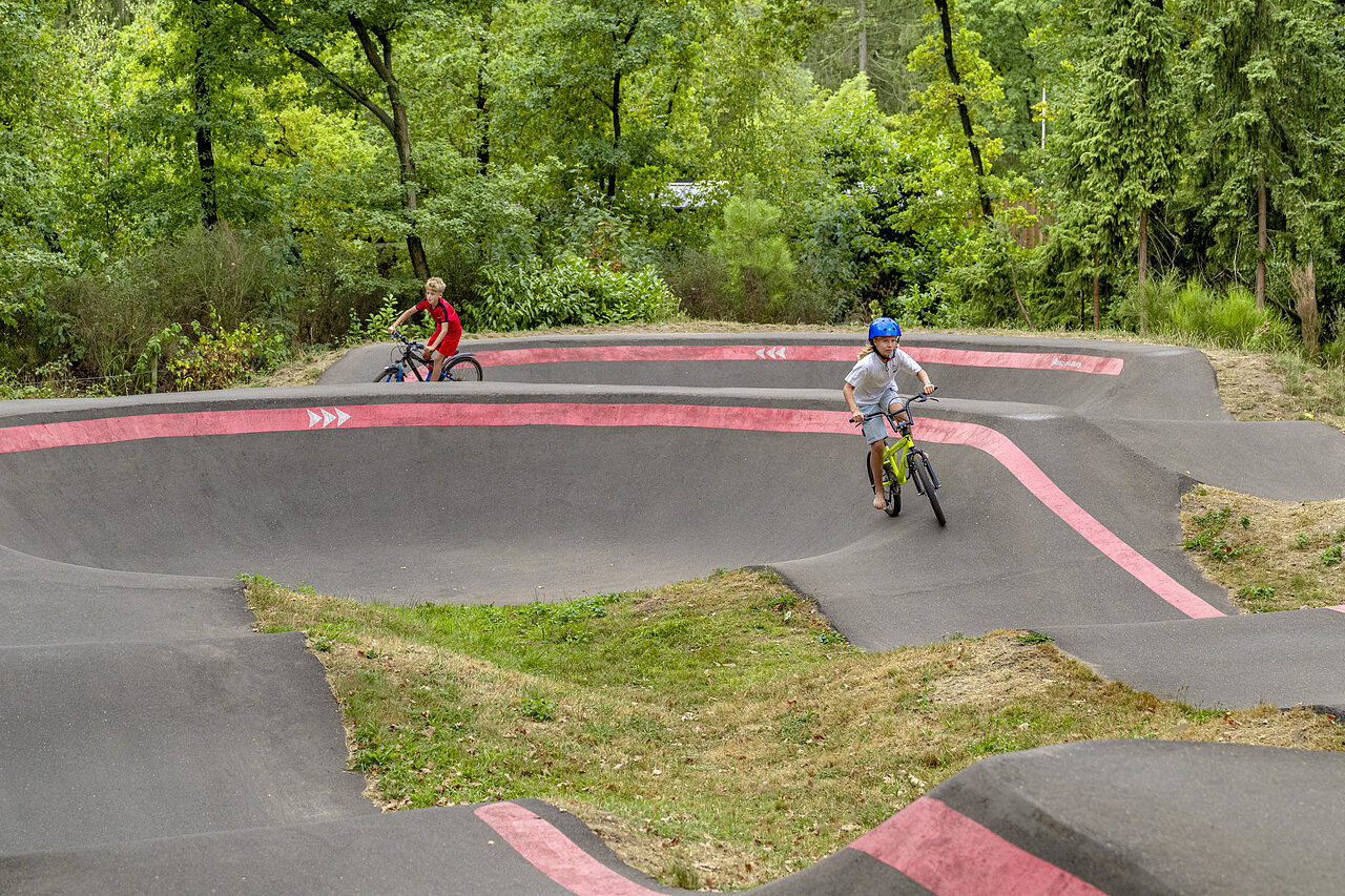 Enfants � v�lo sur la piste de pump track au camping CAPFUN Rakelbos � Westelbeers.