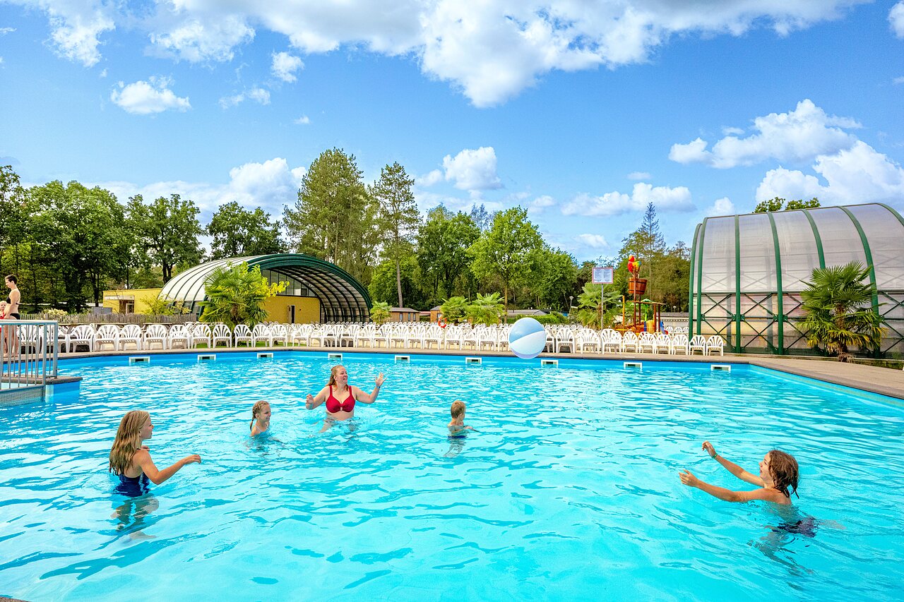 Piscine ext�rieure, famille jouant au ballon, jeux aquatiques au camping CAPFUN Rakelbos.