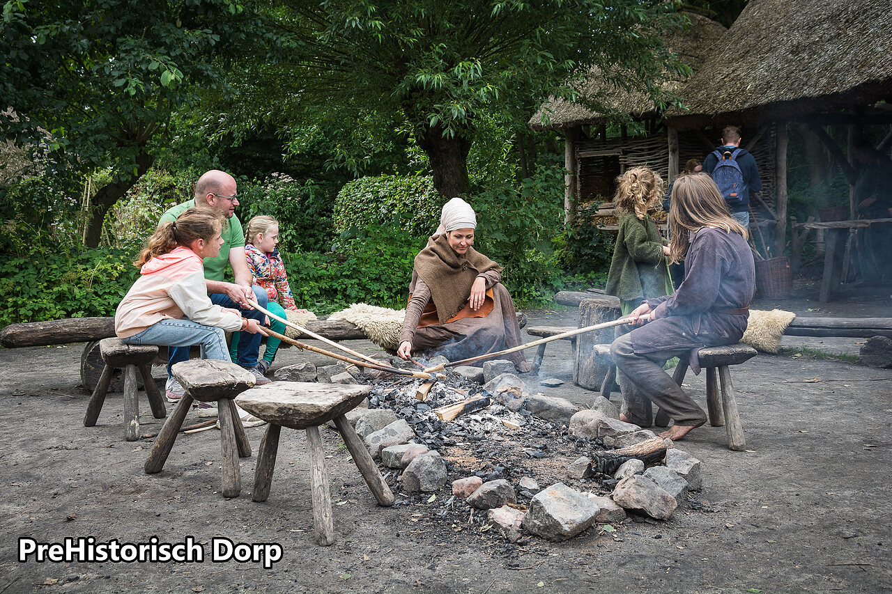 Famille cuisinant au feu de bois dans le village pr�historique d'Eindhoven, Pays-Bas.