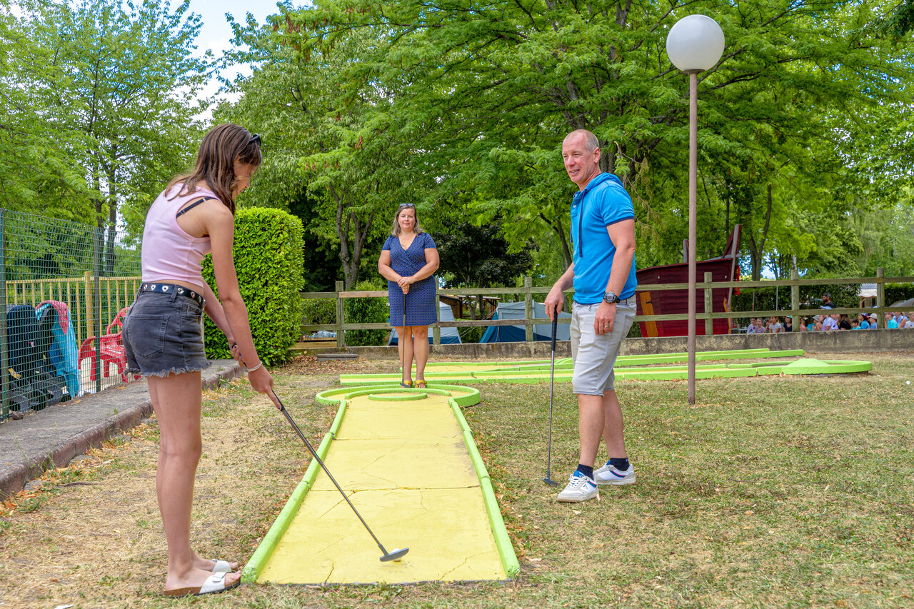 Famille jouant au mini-golf sur un parcours ext�rieur au camping CAPFUN Ranch des Volcans � Chatel-Guyon (63).