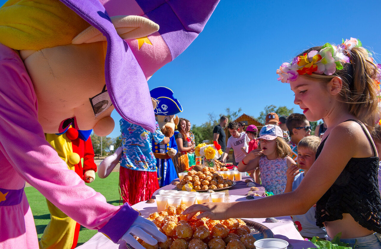 Mascottes et enfants joyeux autour d'un buffet de p�tisseries au camping CAPFUN Ranch des Volcans.
