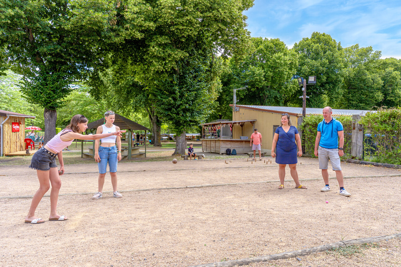 Jeunes et adultes jouant � la p�tanque sur un terrain de sport au camping CAPFUN Ranch des Volcans � Chatel-Guyon (63).