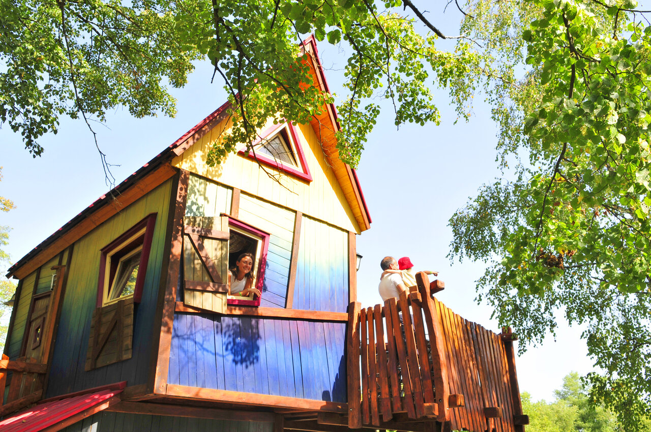 Maison dans les arbres color�e avec famille sur balcon au camping CAPFUN R�gni�re � Villette d'Anthon.