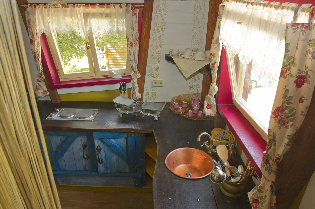 Cuisine rustique �quip�e avec �vier en cuivre au camping CAPFUN R�gni�re : Maisons dans les arbres � Lyon � Villette d'Anthon (38).