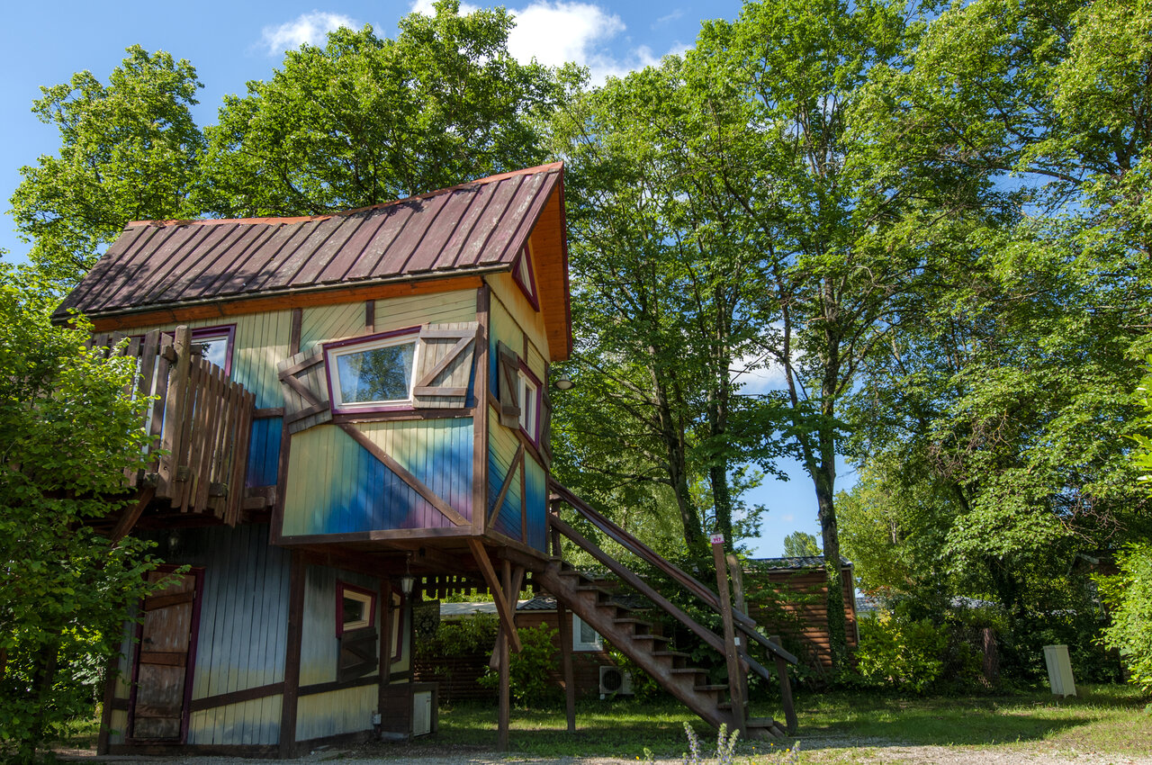 Cabane color�e sur pilotis, h�bergement insolite entour� d'arbres verdoyants au camping CAPFUN R�gni�re : Maisons dans les arbres � Lyon � Villette d'Anthon (38).